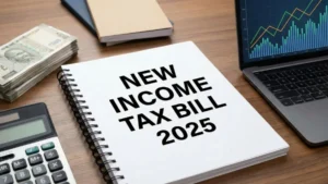 "एक डेस्क पर 'NEW INCOME TAX BILL 2025' लिखा हुआ स्प सर्पिल नोटबुक, जिसके बगल में भारतीय 500 रुपये के नोटों की गड्डी, एक कैलकुलेटर और वित्तीय ग्राफ दिखाता लैपटॉप रखा है।"