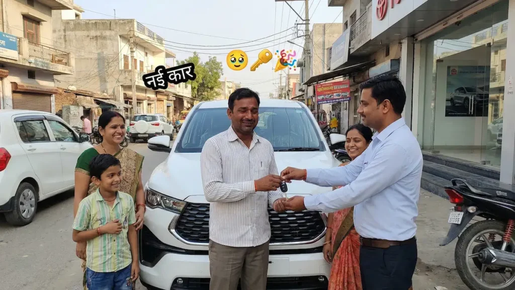 एक मध्यम वर्गीय परिवार टोयोटा इनोवा हाईक्रॉस के सामने खड़ा होकर चाबी ले रहा है, चेहरे पर खुशी और गर्व।